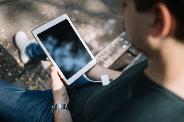 Woman transferring her vacation photos from a tablet to a secure SD card